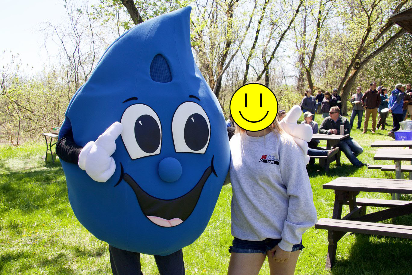 A person in a water drop costume stands next to a girl