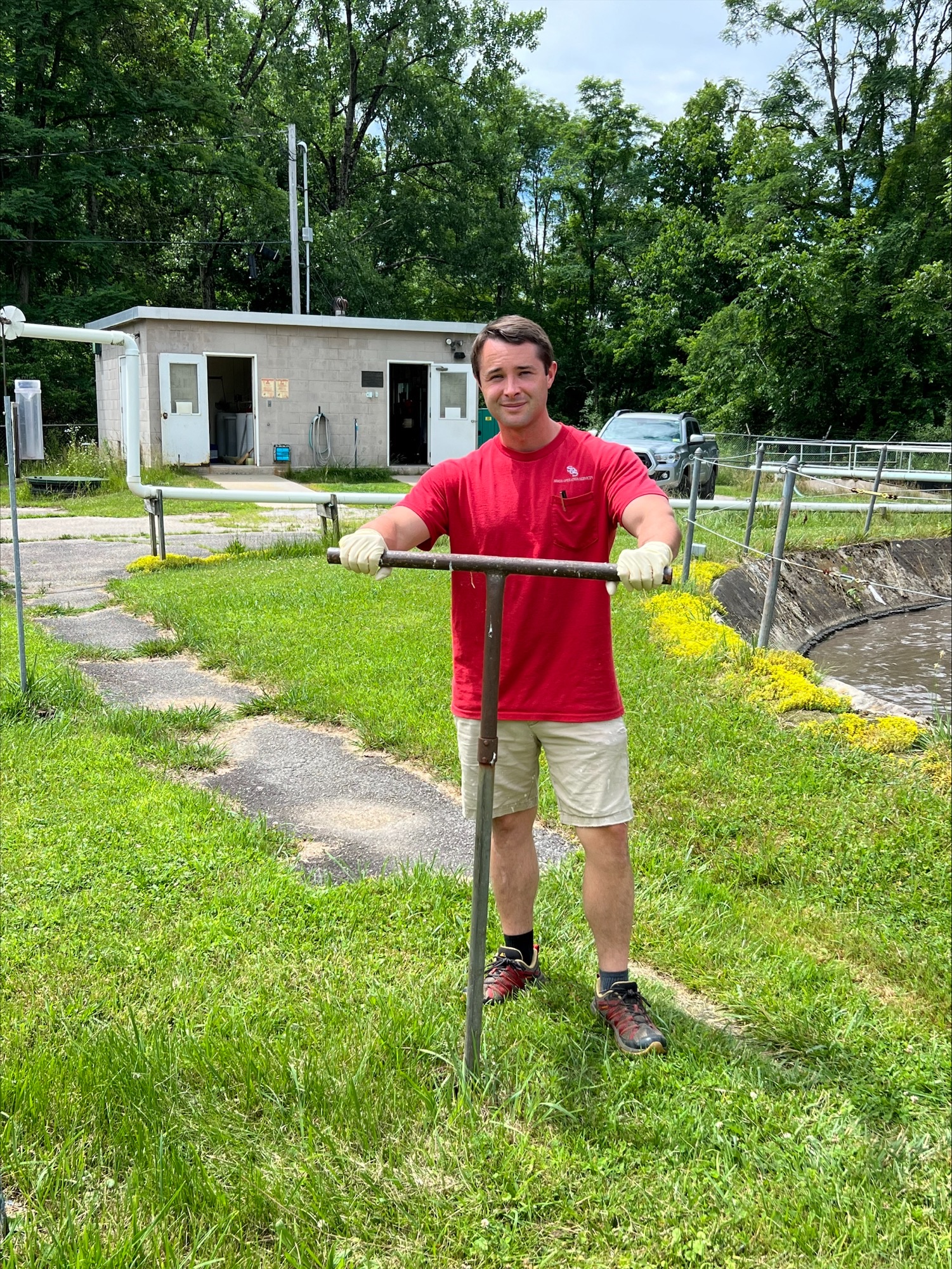 A man in a red shirt holds a valve wrench.