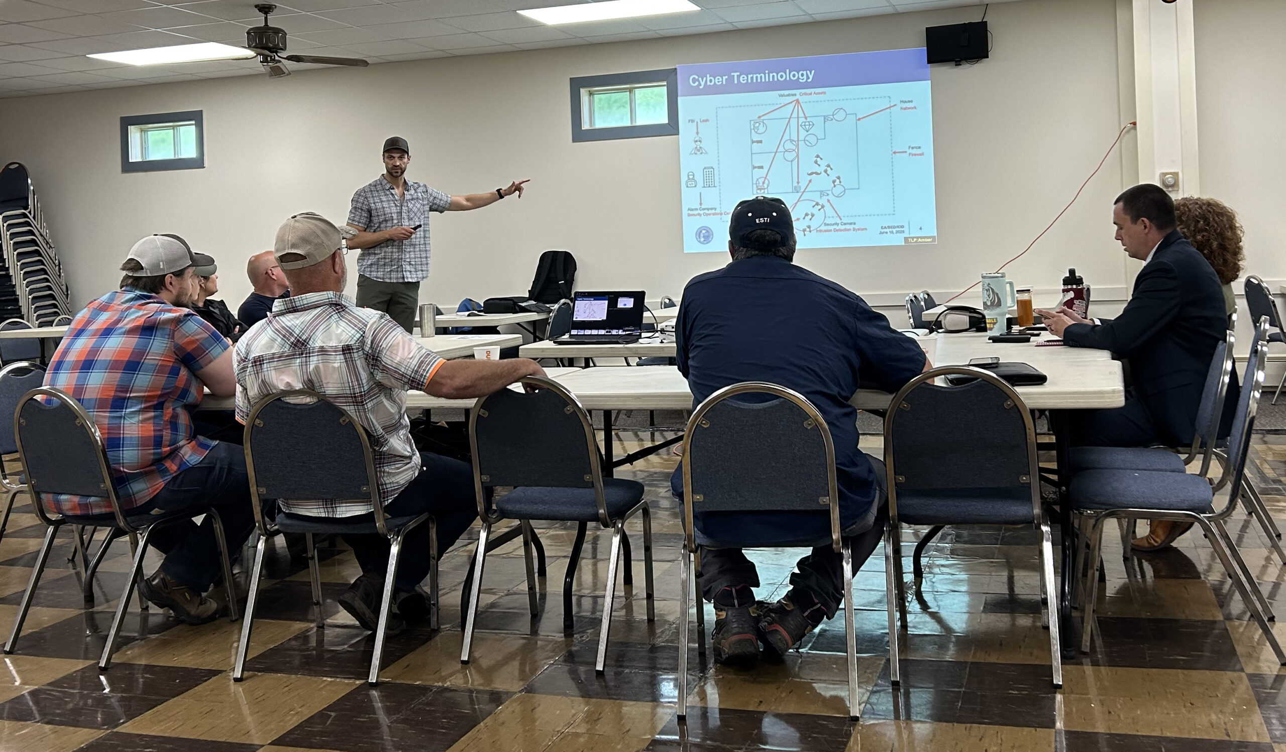 People sit around a U-shaped table facing a slide show