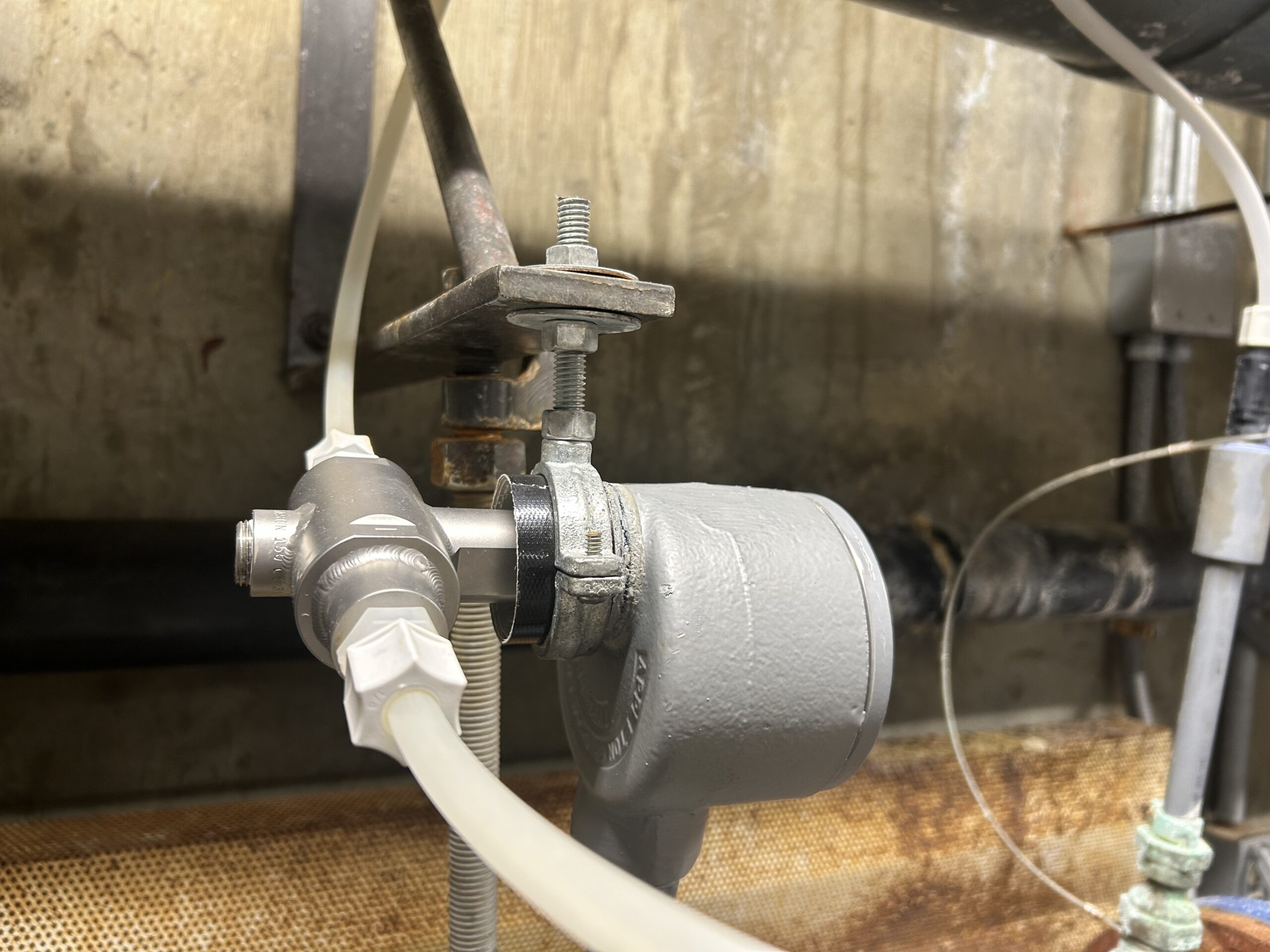 Several buildings stand in a row. There is a propane tank in front. The ground is covered in snow and the sky is blue.